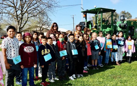 Local elementary schools get a close up lesson about animals and agriculture courtesy of Kings County Farm Bureau Mrs. Barcellos' third grade class pose in front of a tractor during their time at Farm Day.